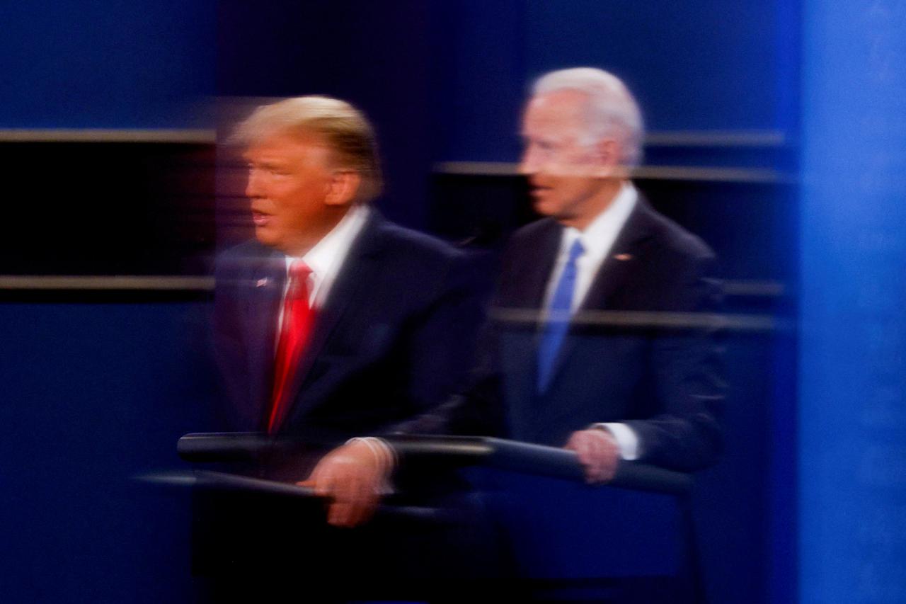 FILE PHOTO: U.S. President Donald Trump and Democratic presidential nominee Joe Biden are reflected in the plexiglass in Nashville