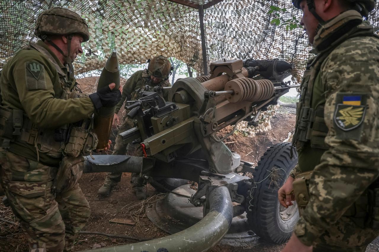 Ukrainian service members fire a L119 howitzer in Donetsk region
