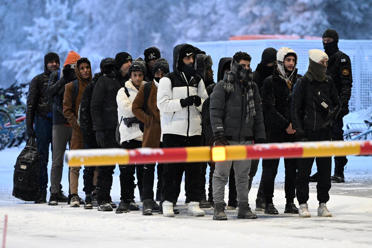 Migrants arrive to the international border crossing at Salla