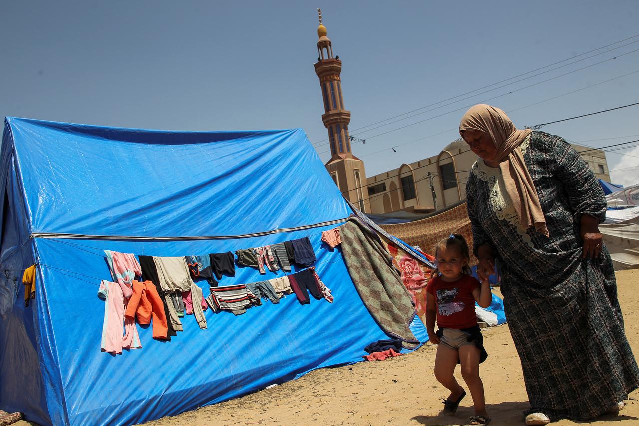 Displaced Palestinians, who fled their houses due to Israeli strikes, shelter at a tent camp in Rafah