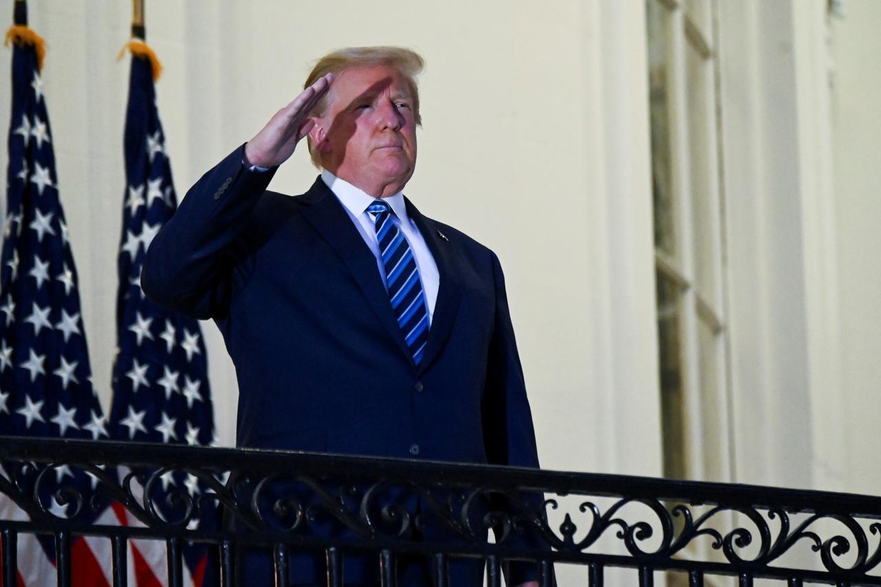 FILE PHOTO: U.S. President Donald Trump poses without face mask as he returns to the White House after being hospitalized at Walter Reed Medical Center for coronavirus disease (COVID-19), in Washington