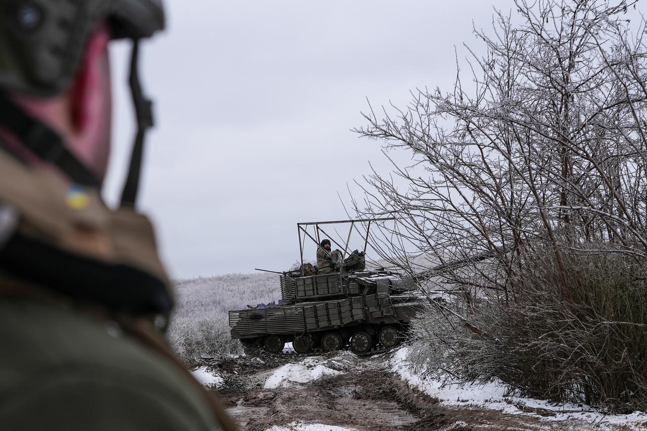 Ukrainian servicemen ride in a tank near the town of Bakhmut