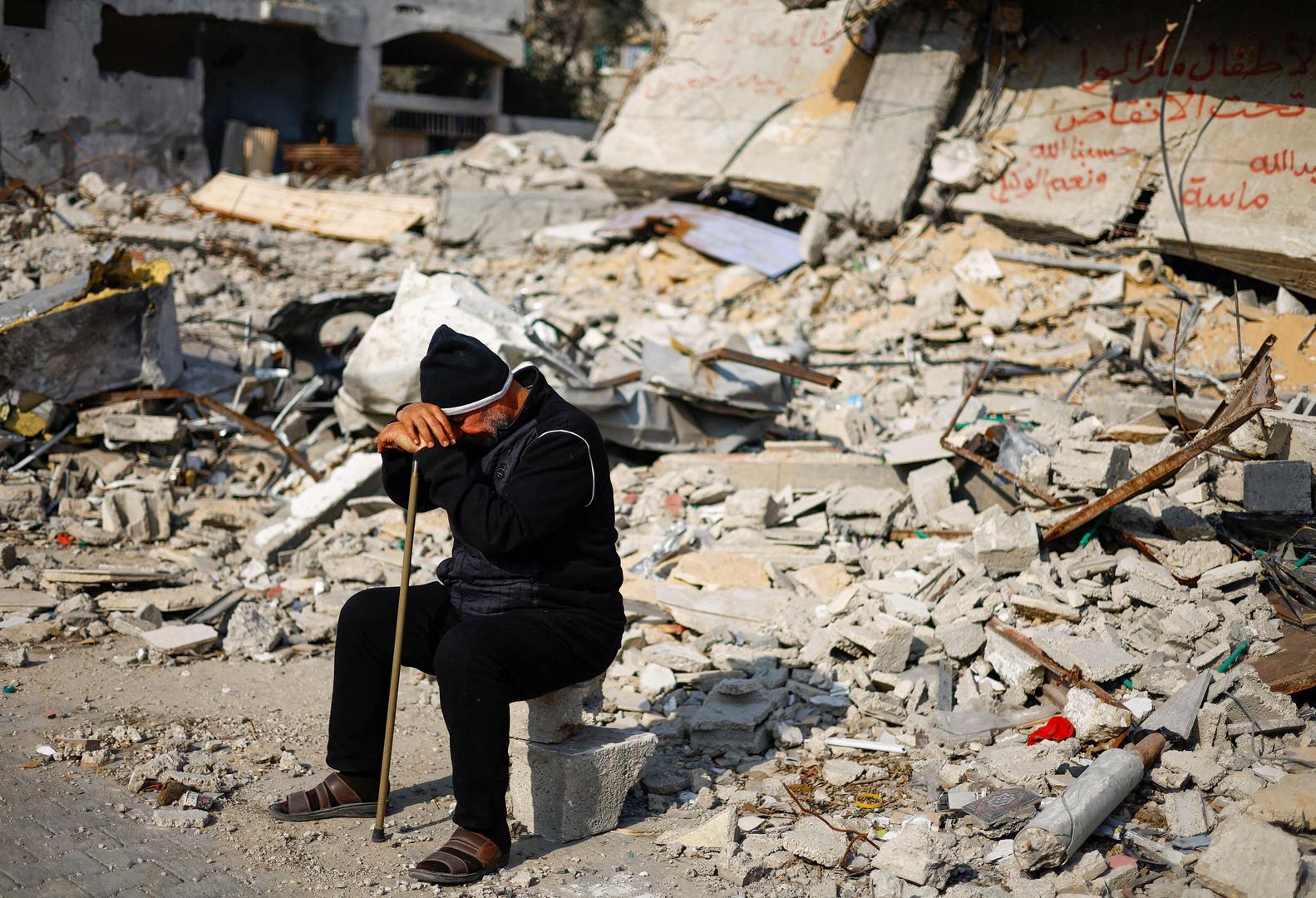 Ziad Mansour, a neighbour of the Abu Aweidah family, sits next to writing painted on a wall amid the rubble of the family's house, which was destroyed in a deadly Israeli strike amid the ongoing conflict between Israel and the Palestinian Islamist group Hamas, in Rafah, Gaza Strip, January 9, 2024. REUTERS/Mohammed Salem Photo: MOHAMMED SALEM/REUTERS