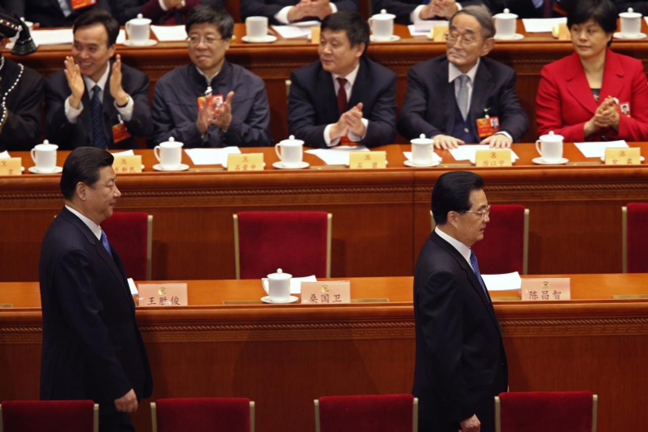 'China's outgoing President Hu Jintao (front row R) and China's Communist Party Chief Xi Jinping arrive as delegates clap during the closing ceremony of the Chinese People's Political Consultative 