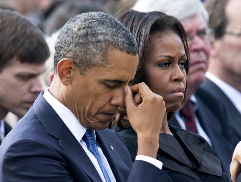 'U.S. President Barack Obama and first lady Michelle Obama sit during a memorial service after visiting with families of the victims of the Washington Navy Yard shooting at Marine Barracks in Washingt