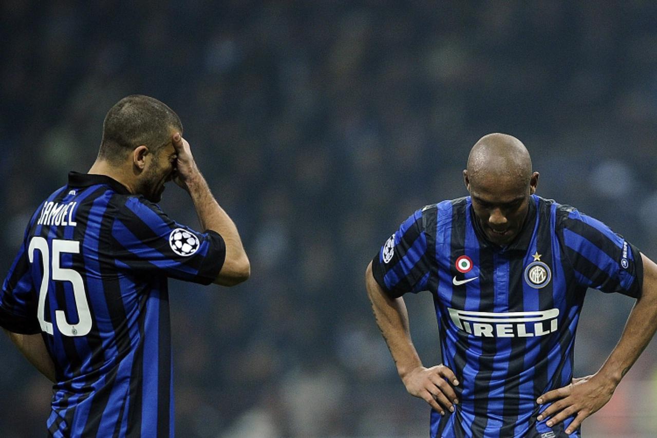 'Inter Milan\'s Argentine defender Adrian Samuel (L) and Milan\'s Brazilian defender Sisenado Douglas Maicon react against Marseille during their second leg Champions League round of 16 football match