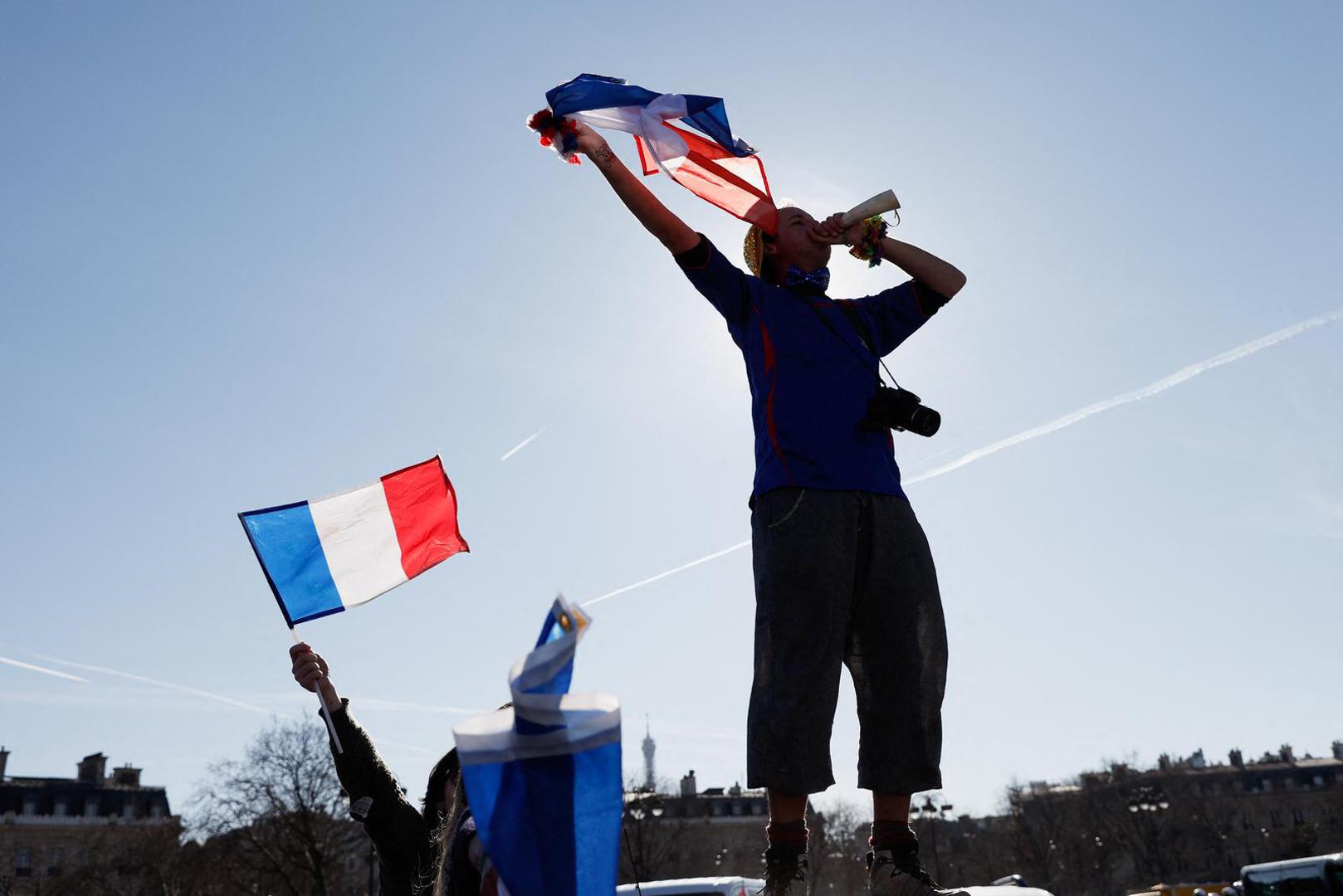 A protester stands atop a vehicle as cars parade during their "Convoi de la liberte" (The Freedom Convoy), a vehicular convoy to protest coronavirus disease (COVID-19) vaccine and restrictions in Paris, France, February 12, 2022. REUTERS/Benoit Tessier Photo: BENOIT TESSIER/REUTERS