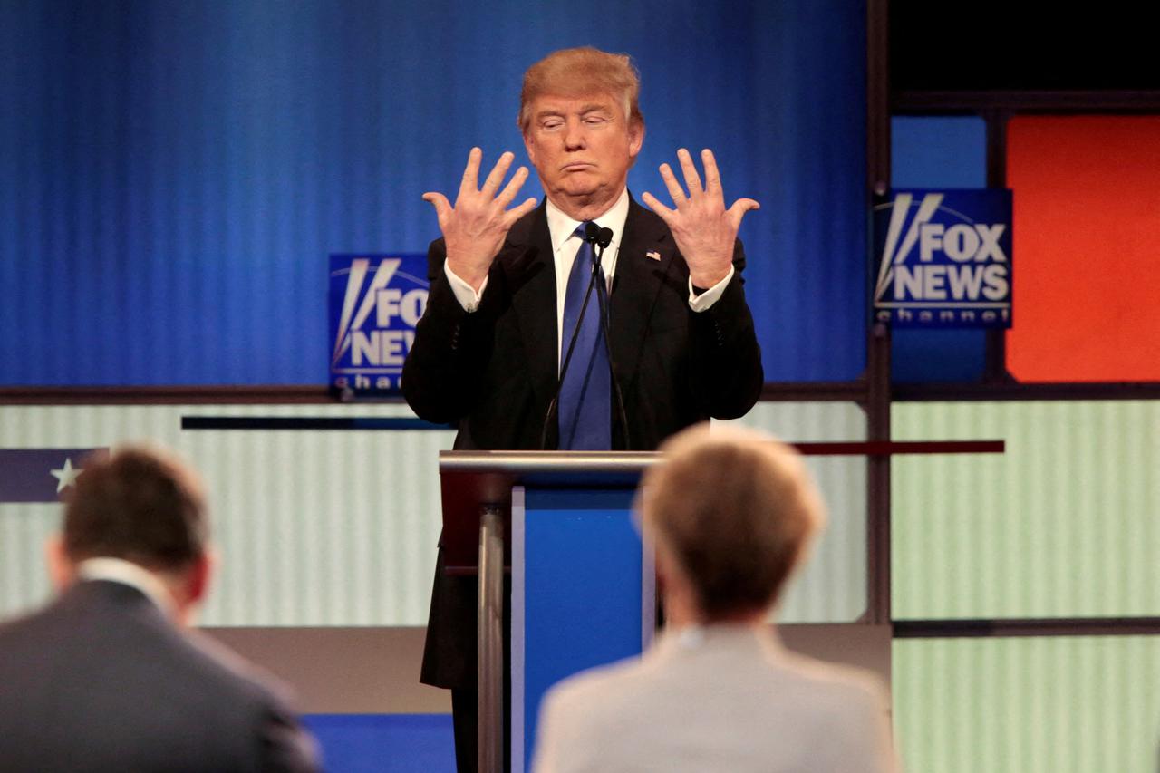 FILE PHOTO: Republican U.S. presidential candidate Trump shows off the size of his hands as Fox News Channel moderators Baier and Kelly look on at the U.S. Republican presidential candidates debate in Detroit
