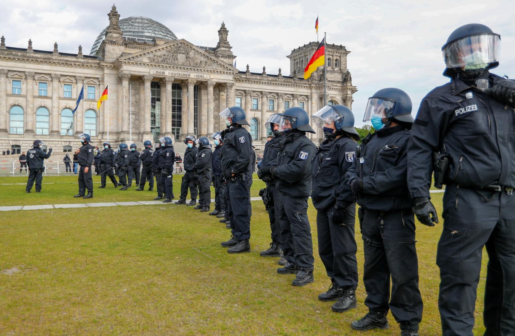 Spread of the coronavirus disease (COVID-19) in Berlin Police officers wearing protective face masks stand guard during a protest against the government's restrictions following the coronavirus disease (COVID-19) outbreak, in front of Reichstag, in Berlin, Germany May 16, 2020. REUTERS/Fabrizio Bensch FABRIZIO BENSCH