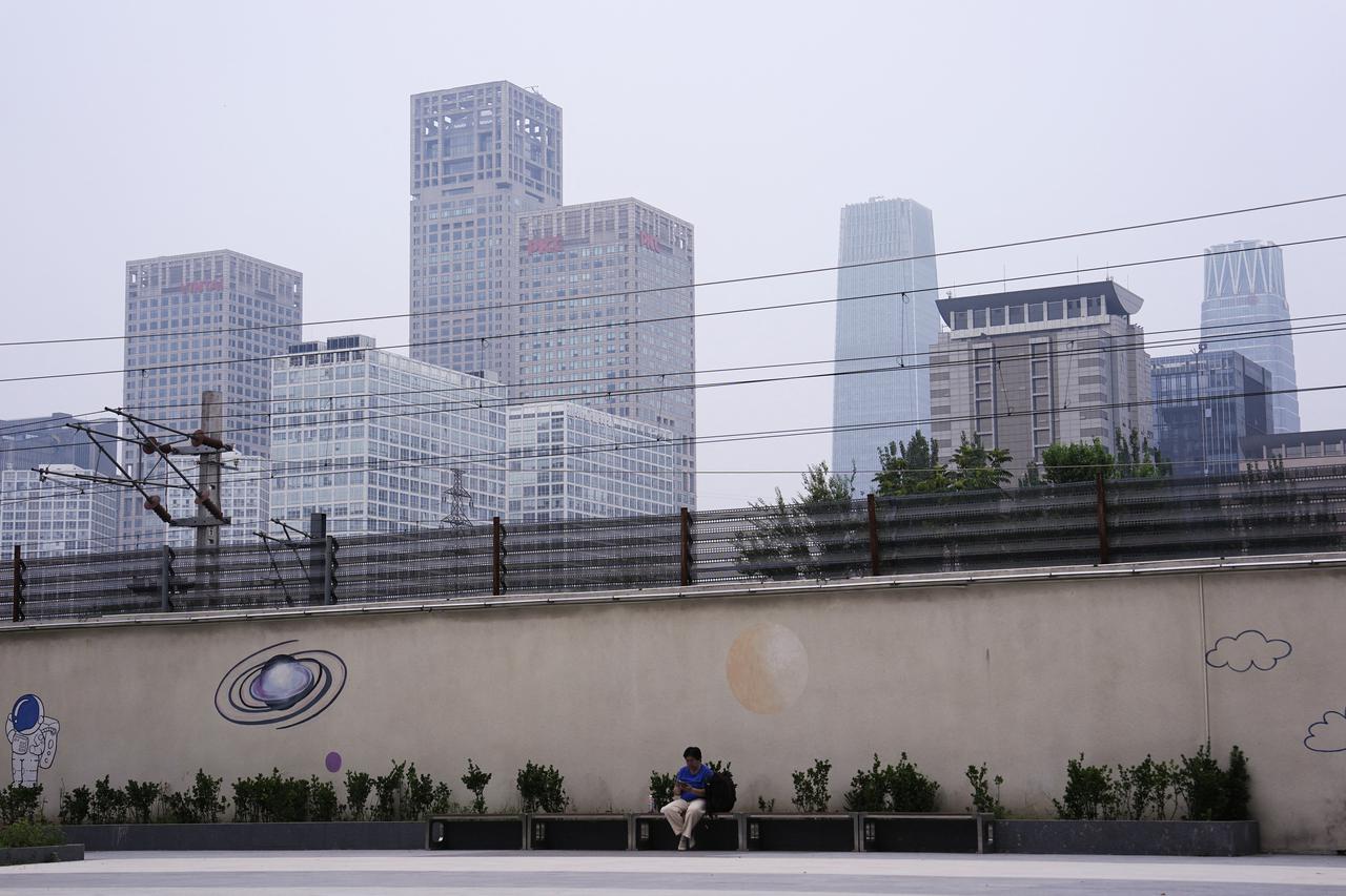 Person sits on a bench near Beijing's Central Business District (CBD)