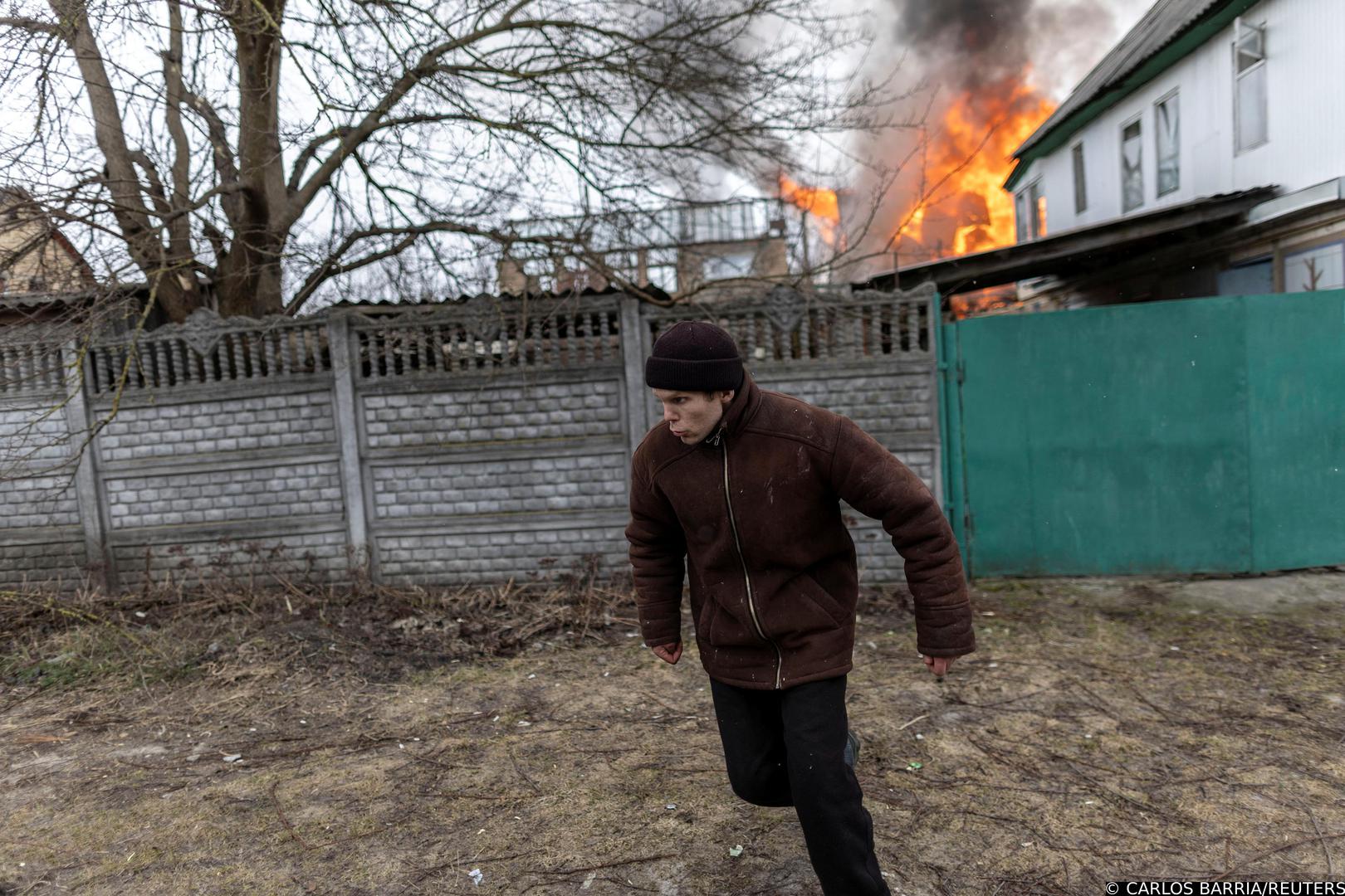 A local resident reacts as a house is on fire after heavy shelling on the only escape route used by locals to leave the town of Irpin, while Russian troops advance toward the capital, 24km from Kyiv, Ukraine March 6, 2022. REUTERS/Carlos Barria Photo: CARLOS BARRIA/REUTERS