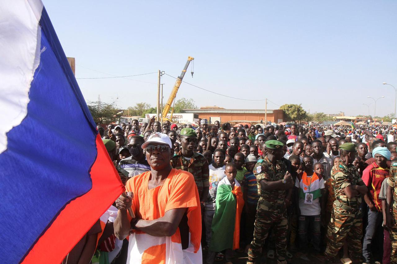 A man waves a Russian flag while attending a sit-in, in Nyamey