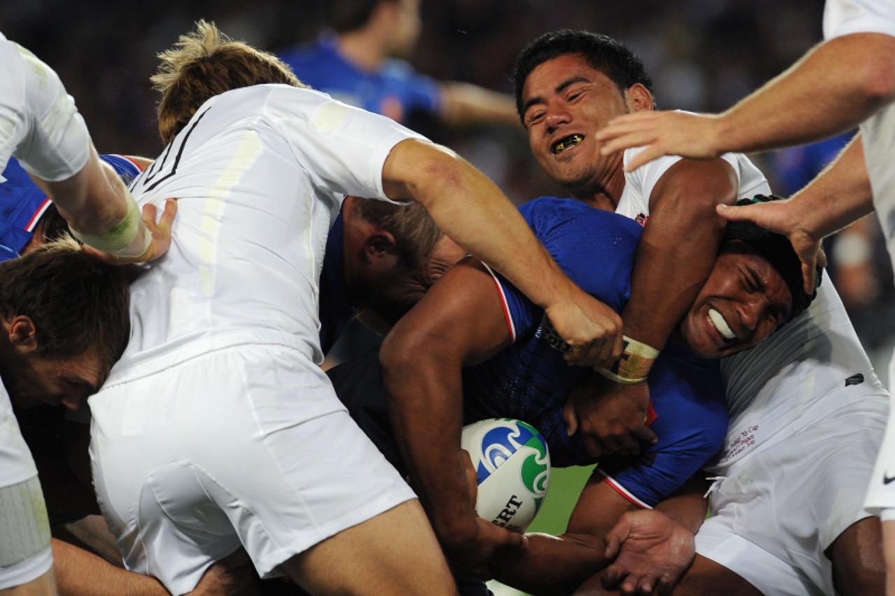 'France\'s flanker Thierry Dusautoir (C) is tackled by England\'s fly-half Jonny Wilkinson (L) and center Manusamoa Tuilagi (upper R) during the 2011 Rugby World Cup quarter-final match France vs Engl