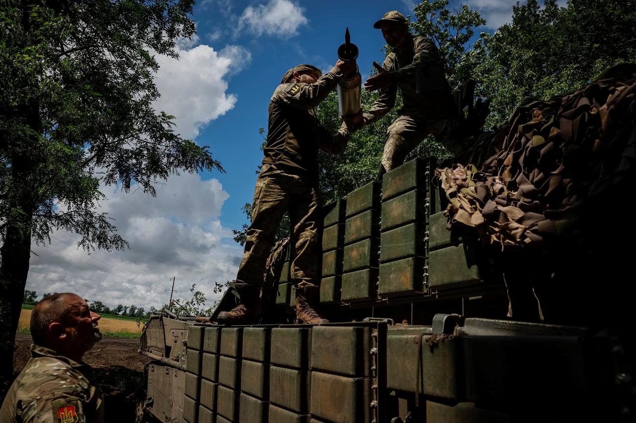 Ukrainian service members load an ammunition to a Leopard 2A4 tank in a workshop at an undisclosed location in the east of Ukraine