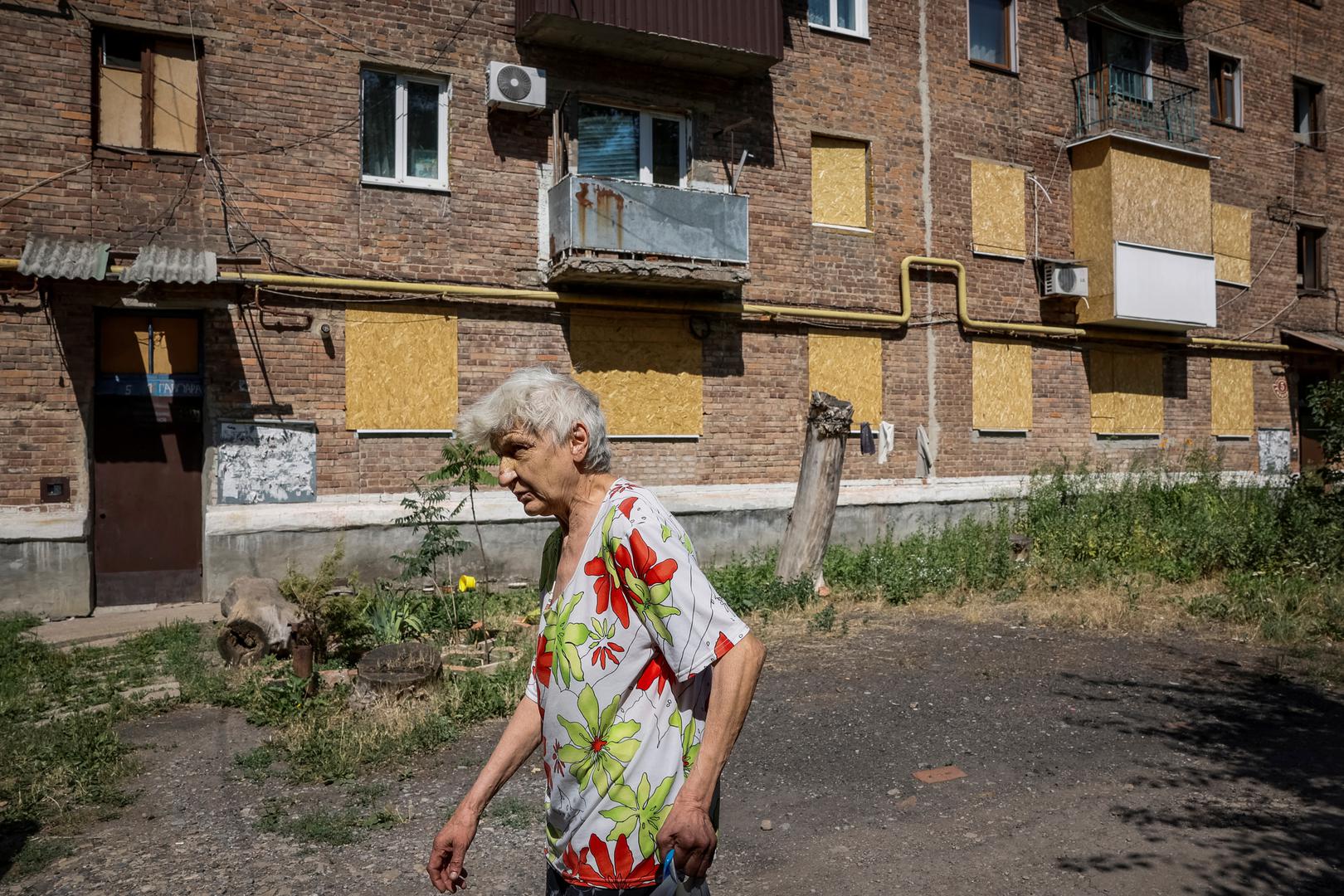 A woman walks by a damaged residential building in the town of Toretsk, amid Russia's attack on Ukraine, near a front line in Donetsk region, Ukraine July 3, 2024. REUTERS/Alina Smutko Photo: ALINA SMUTKO/REUTERS