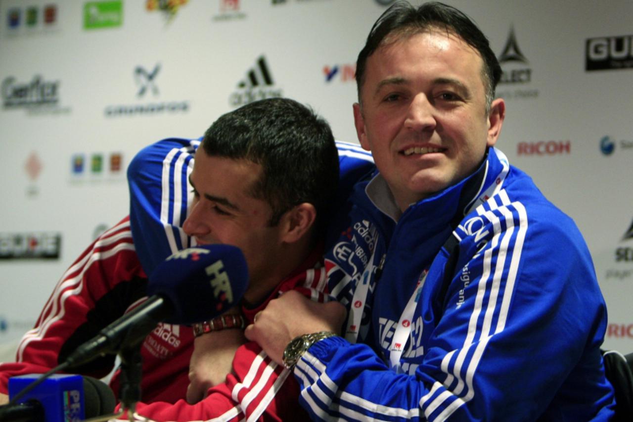 'Croatia\'s head coach Slavko Goluza (R) jokes with player Vedran Zrnic during a media briefing ahead of their match against Romania during the men\'s Handball World Championship in Malmo January 13, 