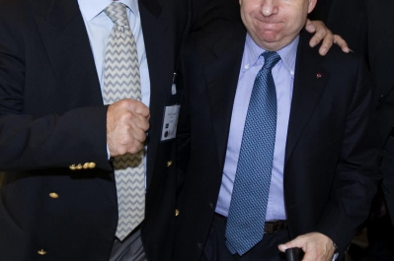 'Former Ferrari team boss Jean Todt (R), flanked by board member Zrinko Gregurek, is congratulated after being elected as new International Automobile Federation (FIA) president during a meeting with 