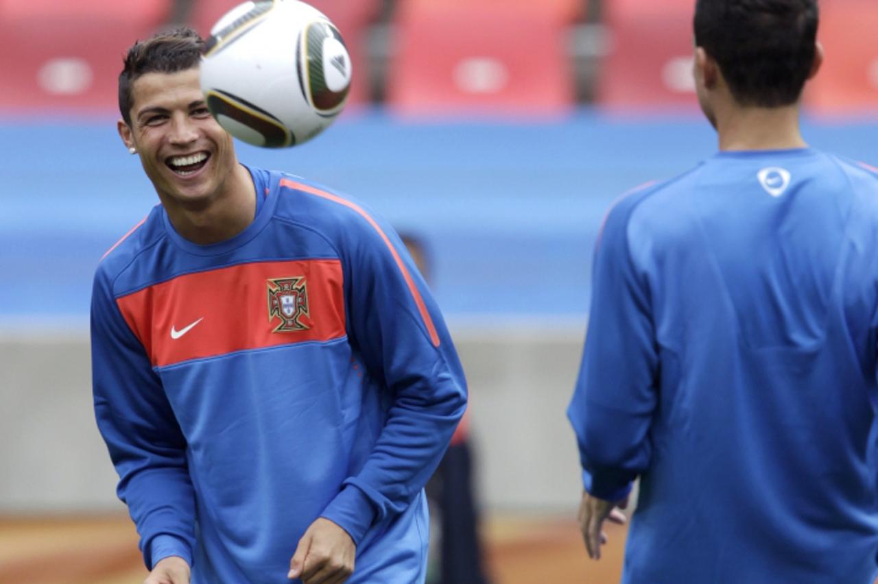 'Portugal\'s national soccer team player Cristiano Ronaldo (L) laughs during a training session at Nelson Mandela Bay Stadium in Port Elizabeth June 14, 2010. Portugal plays in Group G of the 2010 Wor