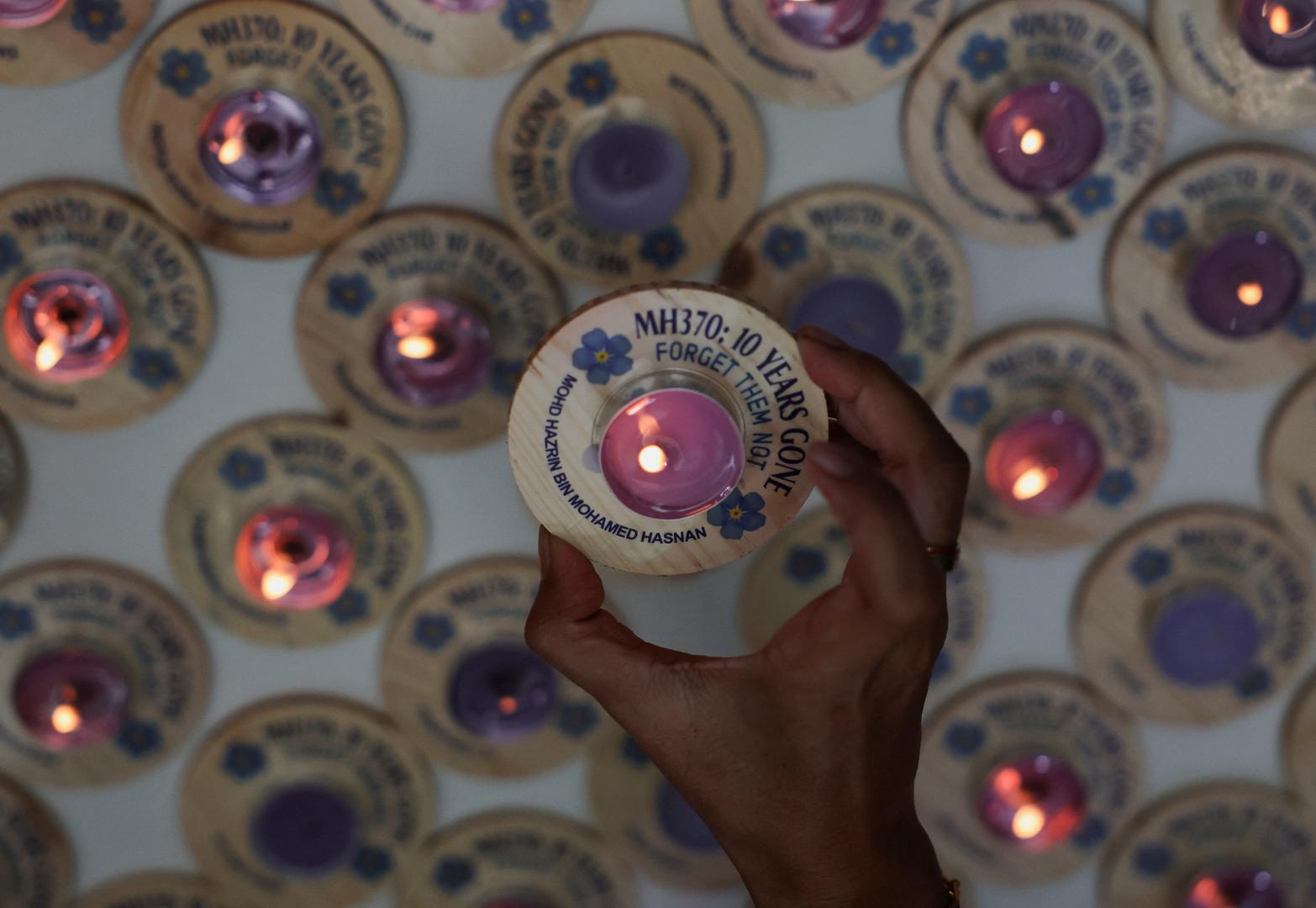 A family member of the missing Malaysia Airlines flight MH370, steward Mohd Hazrin Mohamed Hasnan, holds a candle bearing his name during a remembrance event marking the 10th anniversary of its disappearance, in Subang Jaya, Malaysia March 3, 2024. REUTERS/Hasnoor Hussain Photo: HASNOOR HUSSAIN/REUTERS