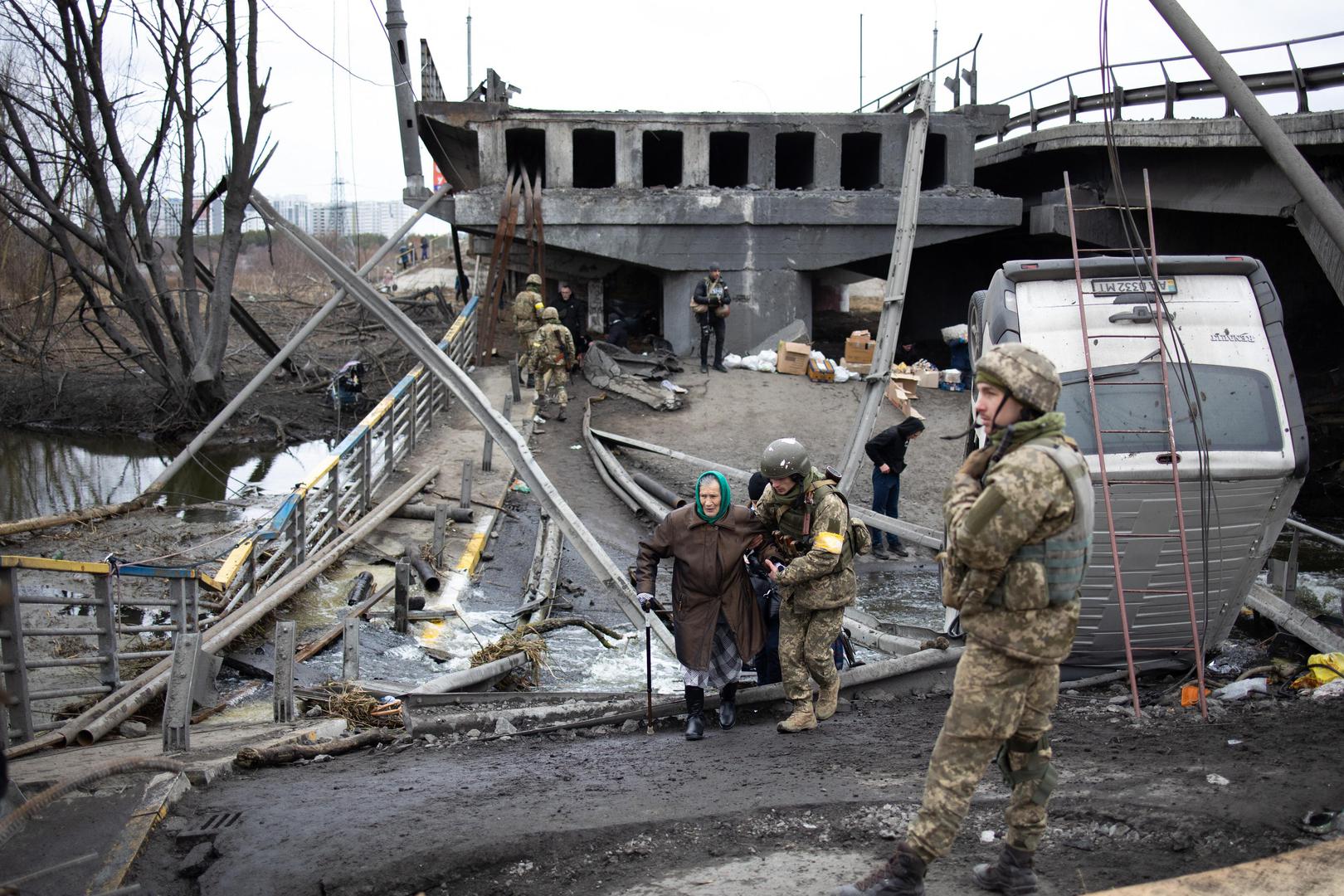 Soldiers help people cross a destroyed bridge as they evacuate the city of Irpin, northwest of Kyiv, during heavy shelling and bombing on March 5, 2022, 10 days after Russia launched a military invasion on Ukraine. Photo by Raphael Lafargue/ABACAPRESS.COM