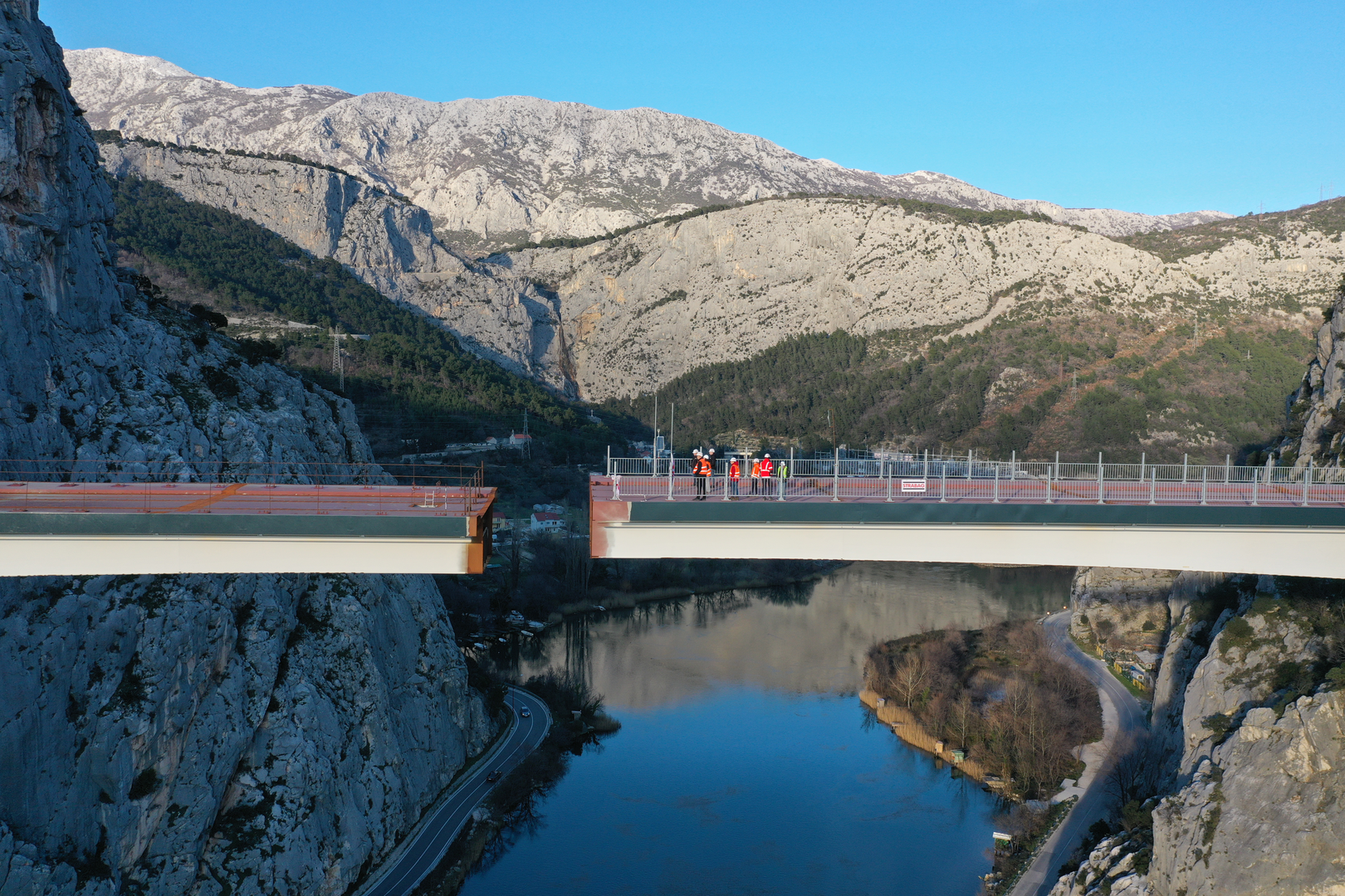 09.02.2023., Omis - Spajanje mosta iznad rijeke Cetine kod Omisa na 70 metara nadmorske visine koji je dio omiske zaobilaznice. Omiska obilaznica jedan od najvecih infrastrukturnih objekata u Splitsko-dalmatinskoj zupaniji, a zaobilaznicu ukljucuju dva tunela i most preko Cetine, tunel Komorjak dug vise od 600 metara, a Omis vise od 500 metara, dok ce most biti u duzini od 216 metara. Investitor je tvrtka Hrvatske ceste, koja je za prvu fazu brze ceste Split - Omis izdvojila 174,5 milijuna kuna, a s radovima se pocelo u rujnu 2019.  Photo: Matko Begovic/PIXSELL