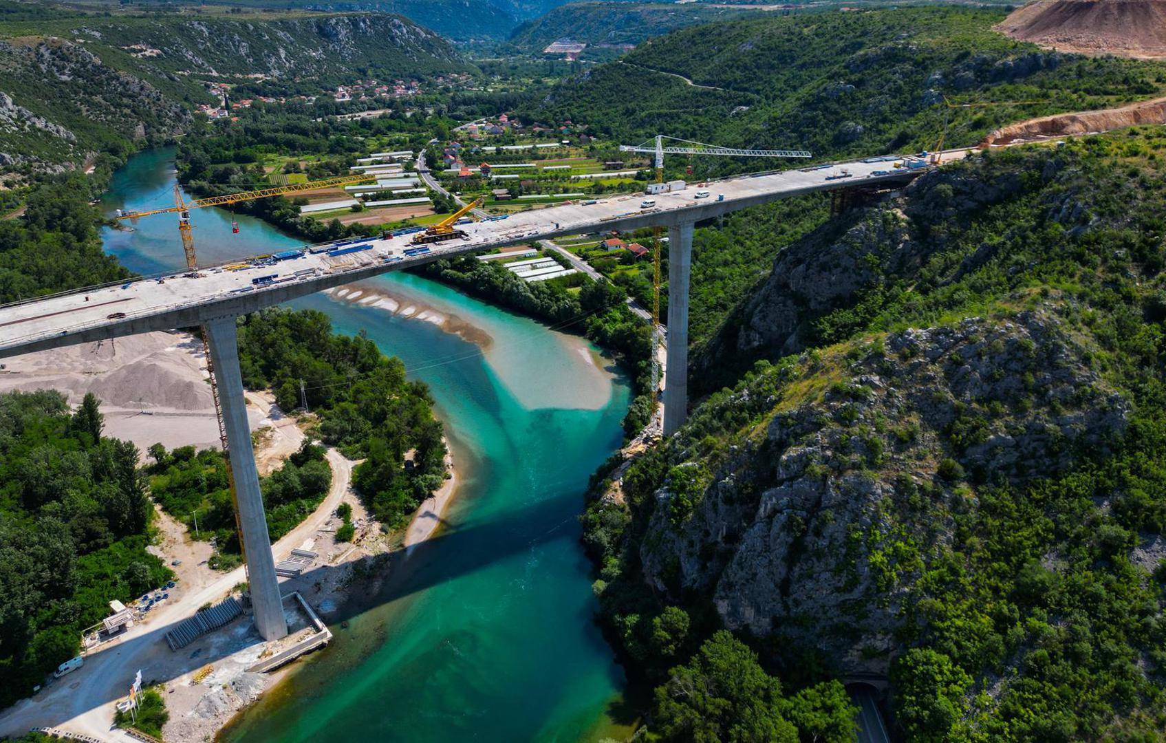 18.06.2023.,Capljina -  Jedan od najvisih mostova u regiji, most Pocitelj uskoro ce biti  spojen s lijevom obalom Neretve. Most Pocitelj visok je nesto vise od stotinu metara, dok njegova duzina iznosi 918 metara. Most ce imati dva vozna traka u svakom smjeru, te je projektiran za brzinu do 130 kilometara na sat. Specificnost ovog mosta je da se citava sirina raspona nalazi na jednostrukom nizu stupova, tj, kolnici nisu fizicki odvojeni. Most Pocitelj najveci je objekt na koridoru Vc. 


 Photo: Denis Kapetanovic/PIXSELL