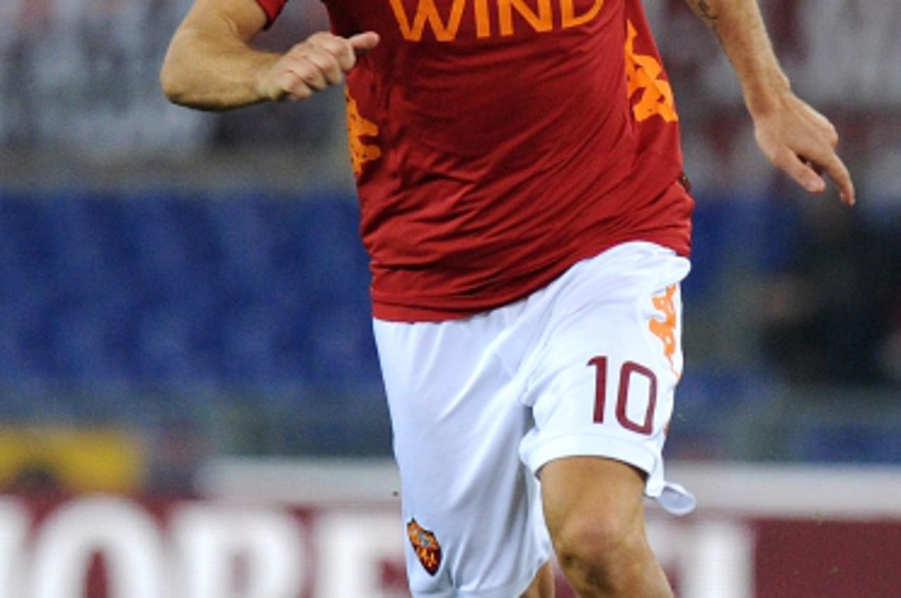 'AS Roma\'s captain Francesco Totti runs with the ball during the Italian Serie A football match between AS Roma and Cesena at the Olympic stadium in Rome on January 21, 2012. AS Roma won the match 5 