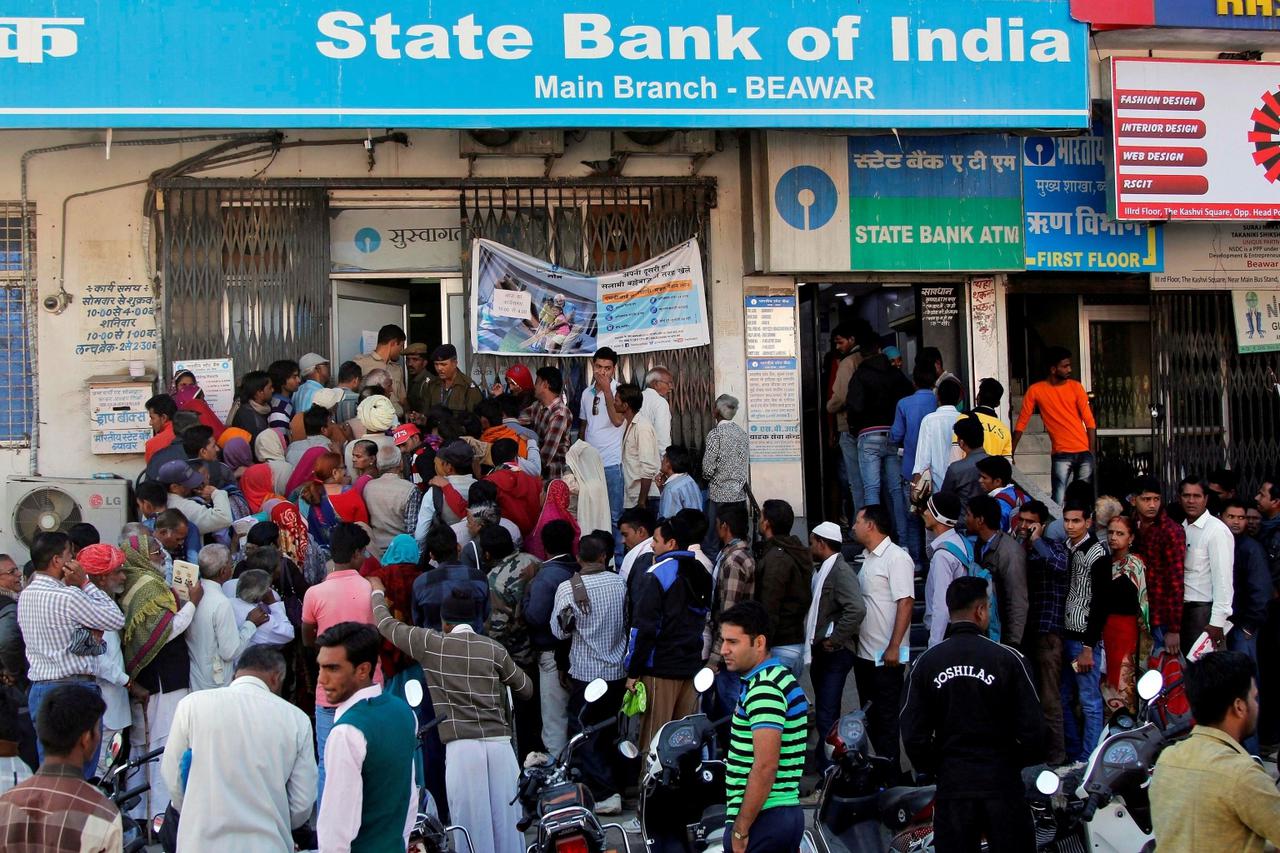 FILE PHOTO: People crowd the entrance of the State Bank of India branch to deposit or exchange their old high denomination banknotes in Beawar city