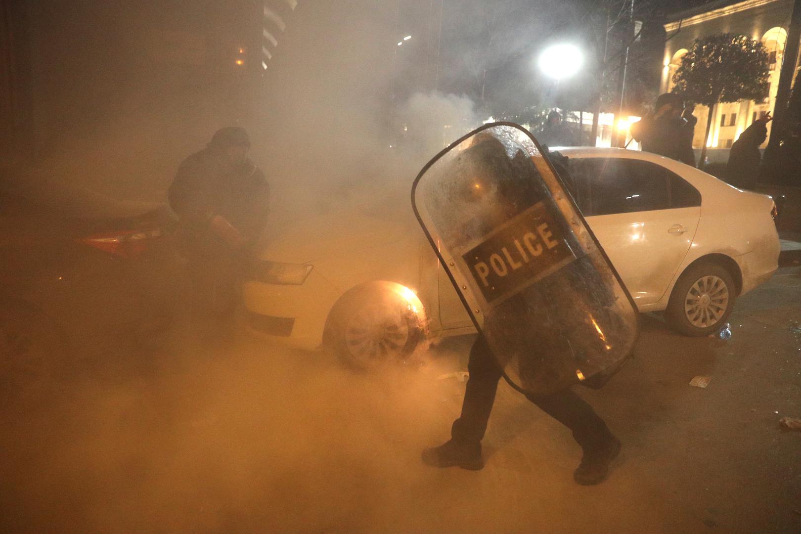 Law enforcement officers approach a car set on fire during a rally against the "foreign agents" law in Tbilisi, Georgia, March 8, 2023. REUTERS/Irakli Gedenidze Photo: IRAKLI GEDENIDZE/REUTERS