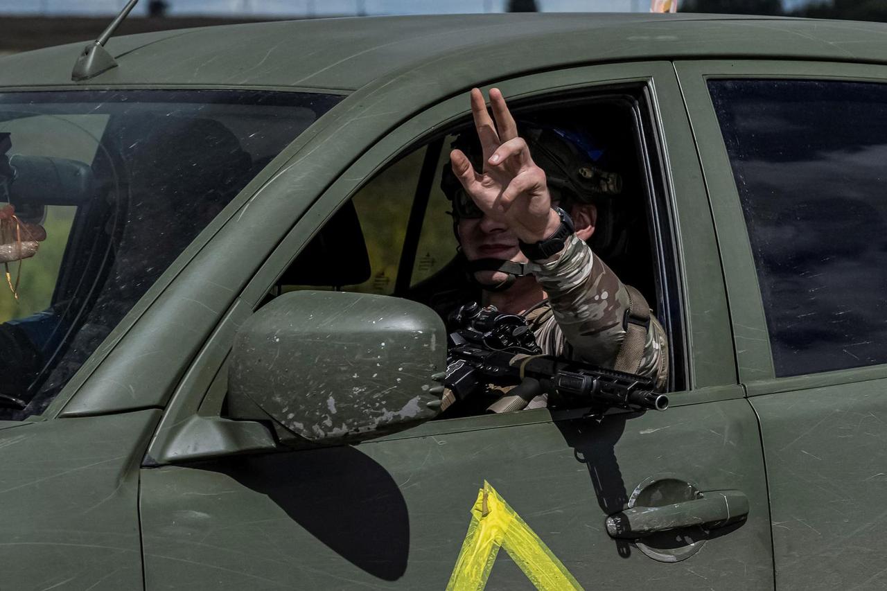 A Ukrainian serviceman rides a military vehicle near the Russian border in Sumy region