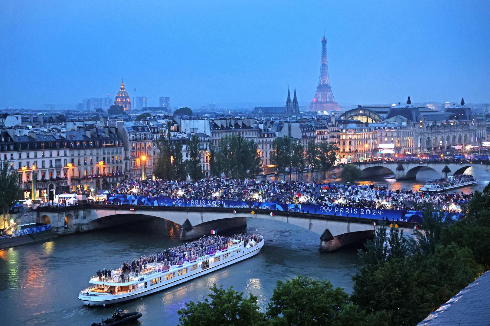 Paris 2024 Olympics - Opening Ceremony - Paris, France - July 26, 2024. Spectators look on as athletes from Team France pass by on a boat on the River Seine during the opening ceremony of the Olympic Games Paris 2024. Richard Heathcote/Pool via REUTERS Photo: Richard HEATHCOTE/REUTERS