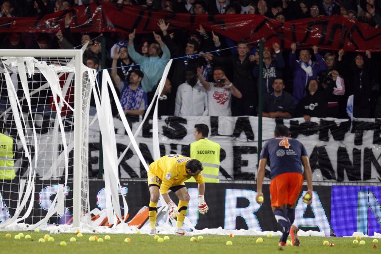 'Montpellier\'s goalkeeper Geoffrey Jourdren (L) and Hilton remove tennis balls from the field during their final French Ligue 1 soccer match agaist Auxerre at the Abbe Deschamps stadium in Auxerre, M