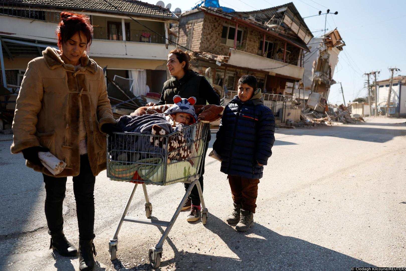 Parlakgun family return to their tent with mother Tulay pushing baby Salih in a shopping trolly through the destroyed streets in the aftermath of a deadly earthquake in Hatay, Turkey February 14, 2023. REUTERS/Clodagh Kilcoyne Photo: Clodagh Kilcoyne/REUTERS