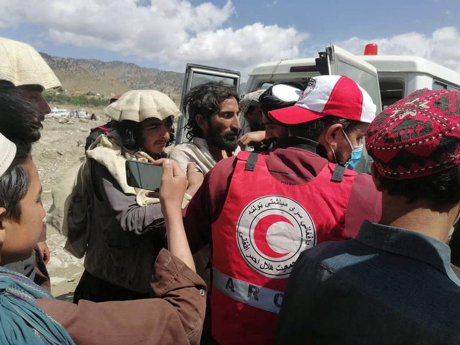 Afghan Red Crescent medics and volunteers transport earthquake victims to hospitals, in Spera district