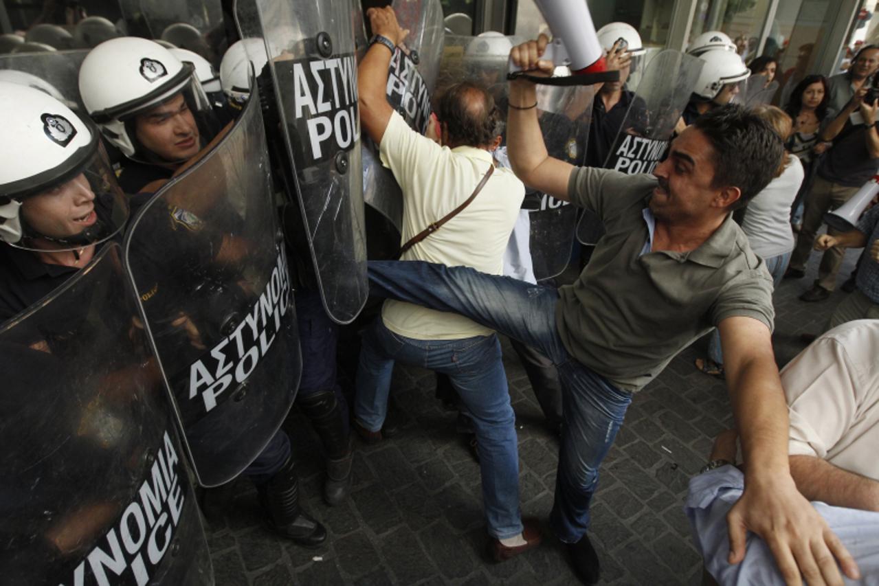 'An employee of the Finance Ministry kicks a riot policeman during a protest against the government\'s austerity measures at the entrance of the ministry in Athens, September 27, 2011. Greek lawmakers