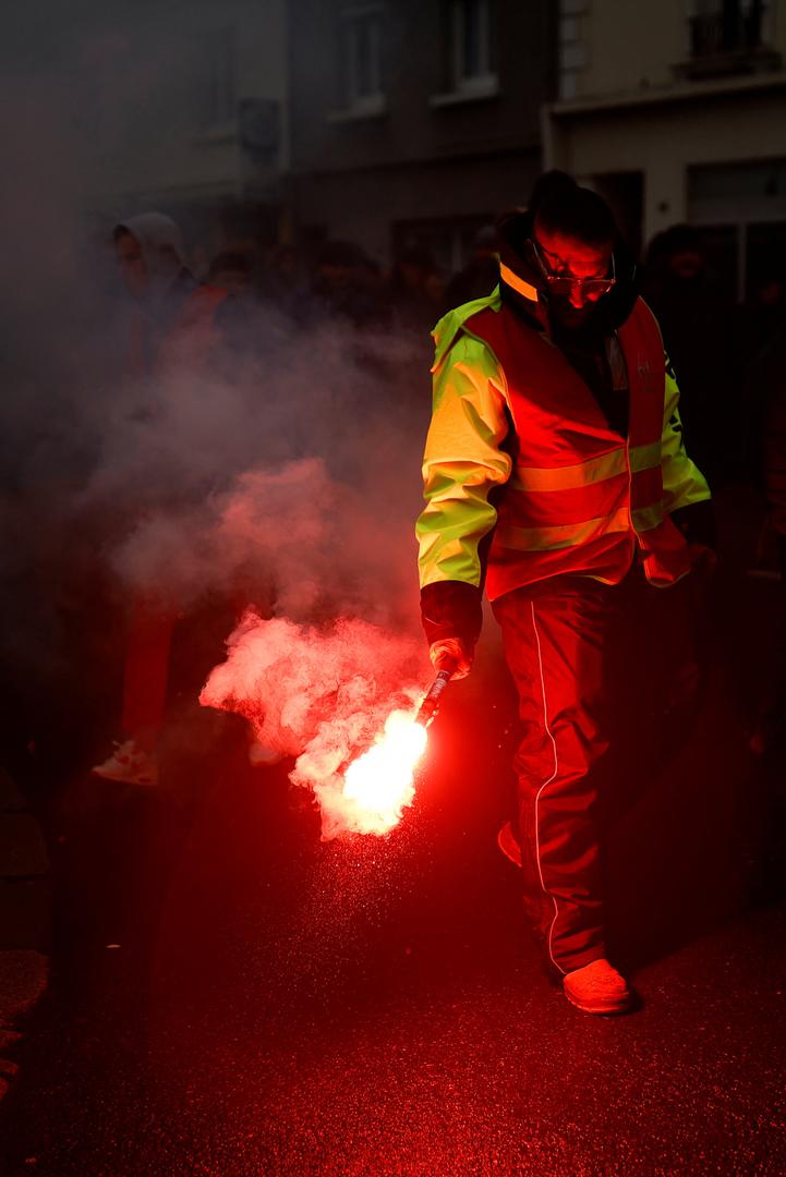 A protester holds a flare during a demonstration against French government's pension reform plan in Saint-Nazaire as part of a day of national strike and protests in France, January 19, 2023. REUTERS/Stephane Mahe Photo: STEPHANE MAHE/REUTERS