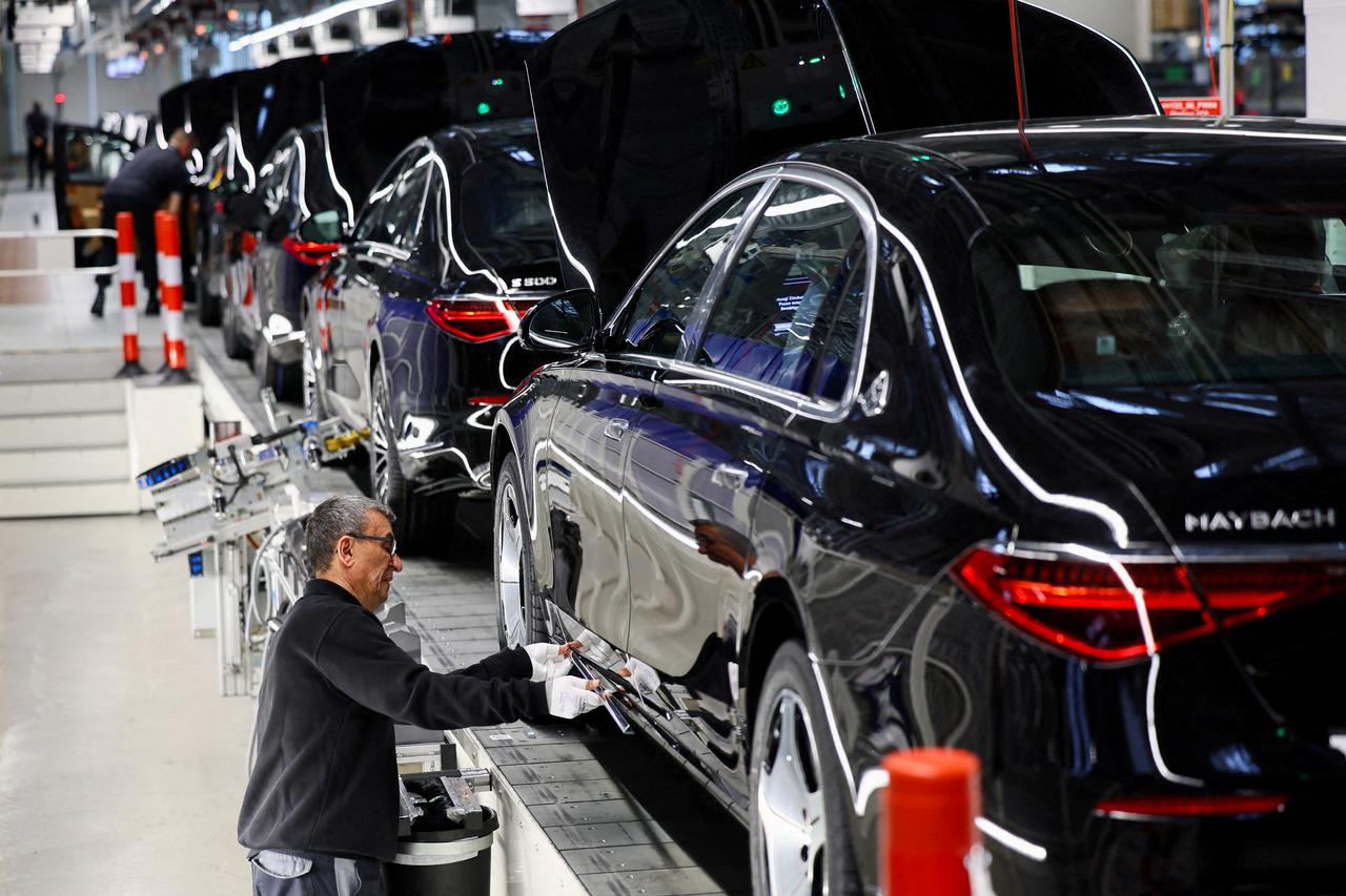 FILE PHOTO: A worker attaches a part to a Mercedes-Maybach car on a production line of "Factory 56" in Sindelfingen