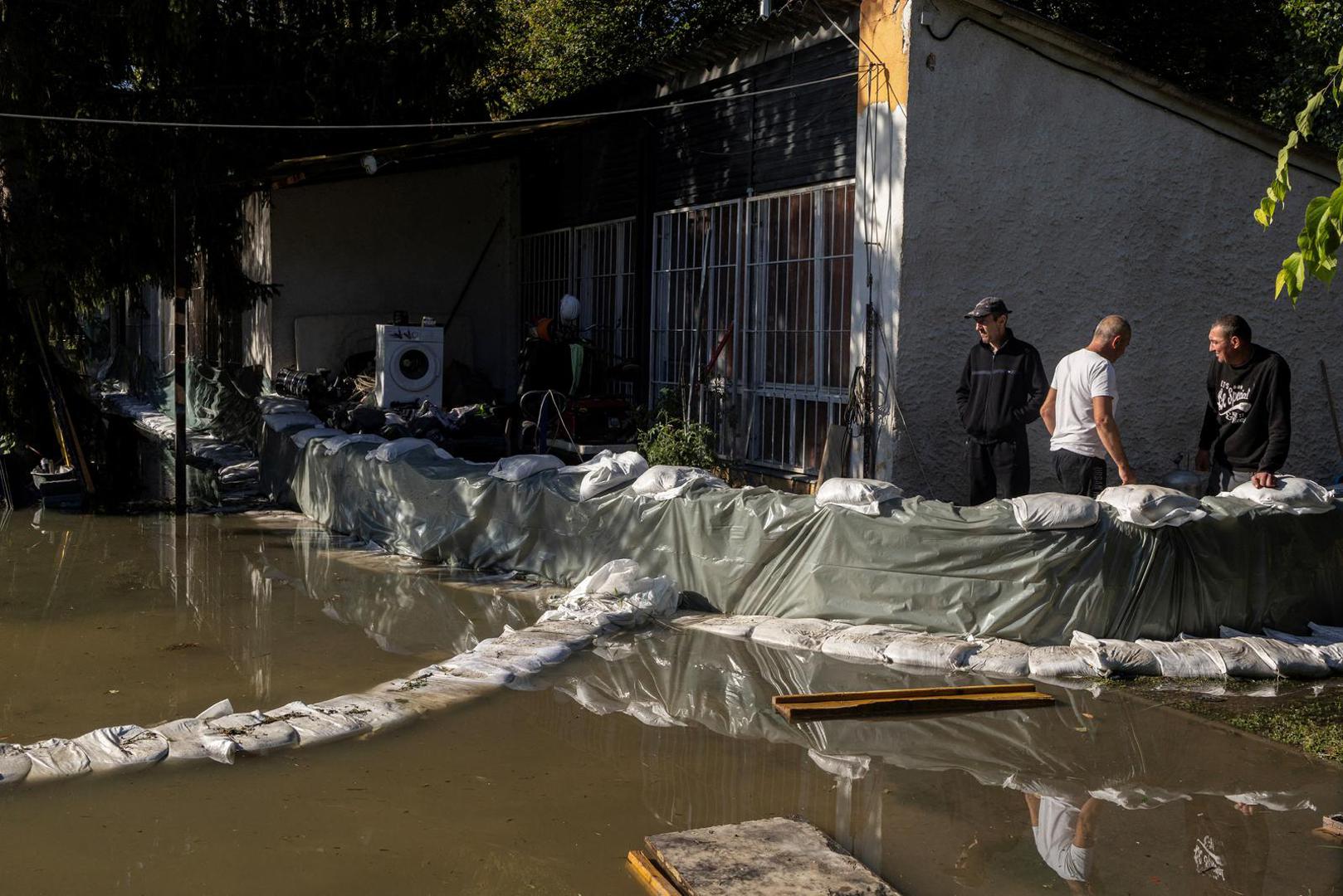 People stand next to a house flooded by the Danube river in Budapest, Hungary, September 21, 2024. REUTERS/Marko Djurica Photo: MARKO DJURICA/REUTERS