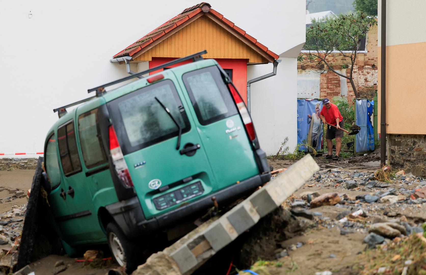 A man clears mud next to a building near a damaged vehicle, in the aftermath of flooding following heavy rainfalls, in Jesenik, Czech Republic, September 16, 2024. REUTERS/David W Cerny Photo: DAVID W CERNY/REUTERS