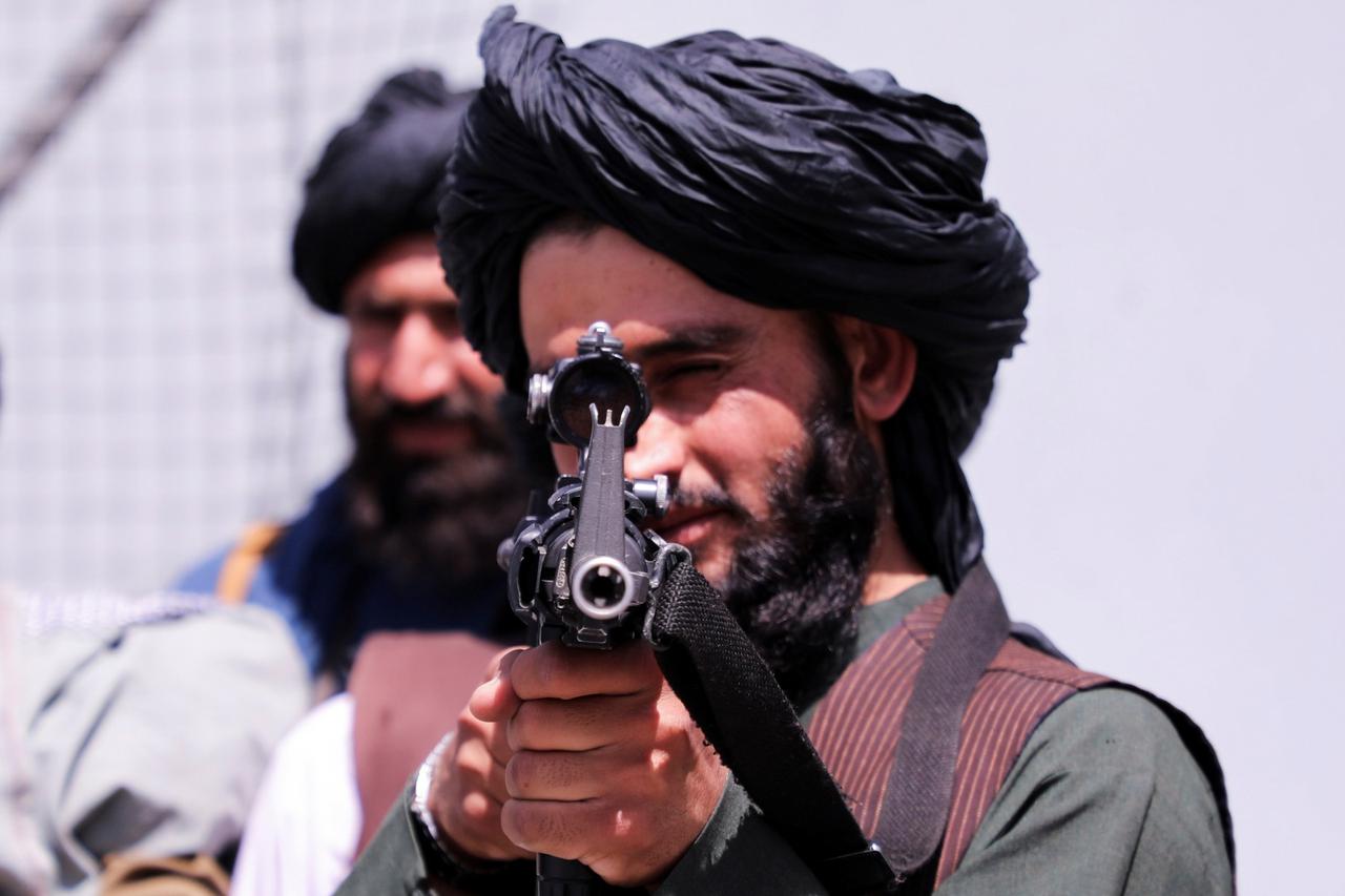 Taliban forces stand guard in front of Hamid Karzai International Airport in Kabul