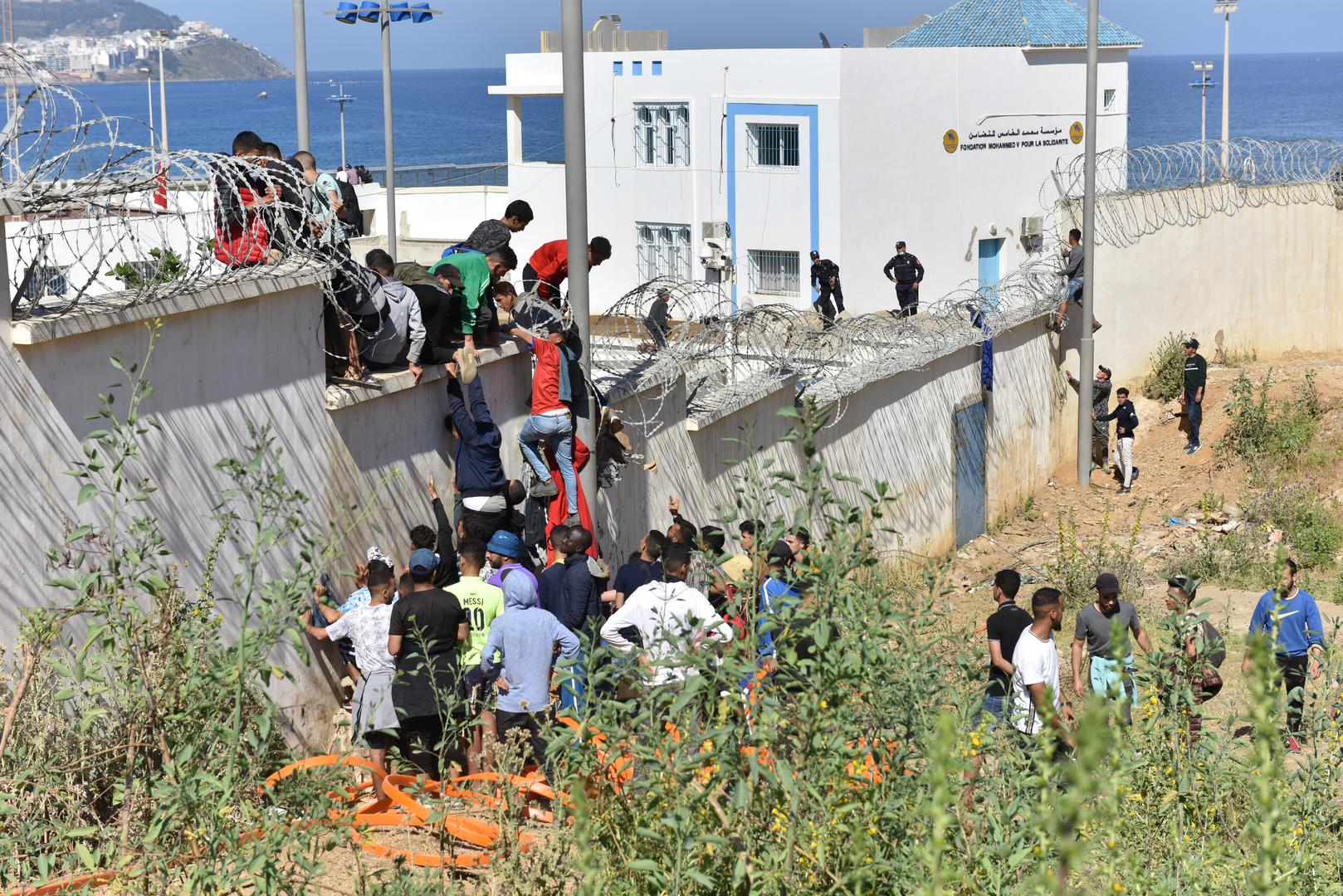 MOROCCO-FNIDEQ-SPAIN-IMMIGRANTS                                                                                                                                          (210519) -- FNIDEQ, May 19, 2021 (Xinhua) -- Immigrants climb over the border fence to enter the Spanish enclave of Ceuta, in Fnideq, Morocco, May 18, 2021. The Spanish enclave of Ceuta is having to deal with an influx of immigrants after an estimated 6,000 people have entered the territory from Morocco, according to the central government's delegation in the city. (Xinhua) Xinhua  Photo: XINHUA/PIXSELL