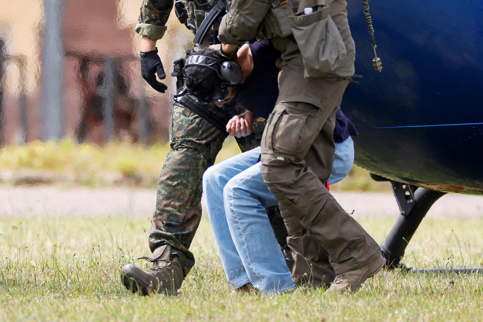 A 26-year-old Syrian man, who is the suspect in custody for a stabbing rampage in the western German city of Solingen in which several individuals were killed, is escorted by police on his way to the Federal Public Prosecutor in Karlsruhe, Germany, August 25, 2024. REUTERS/Heiko Becker Photo: Heiko Becker/REUTERS