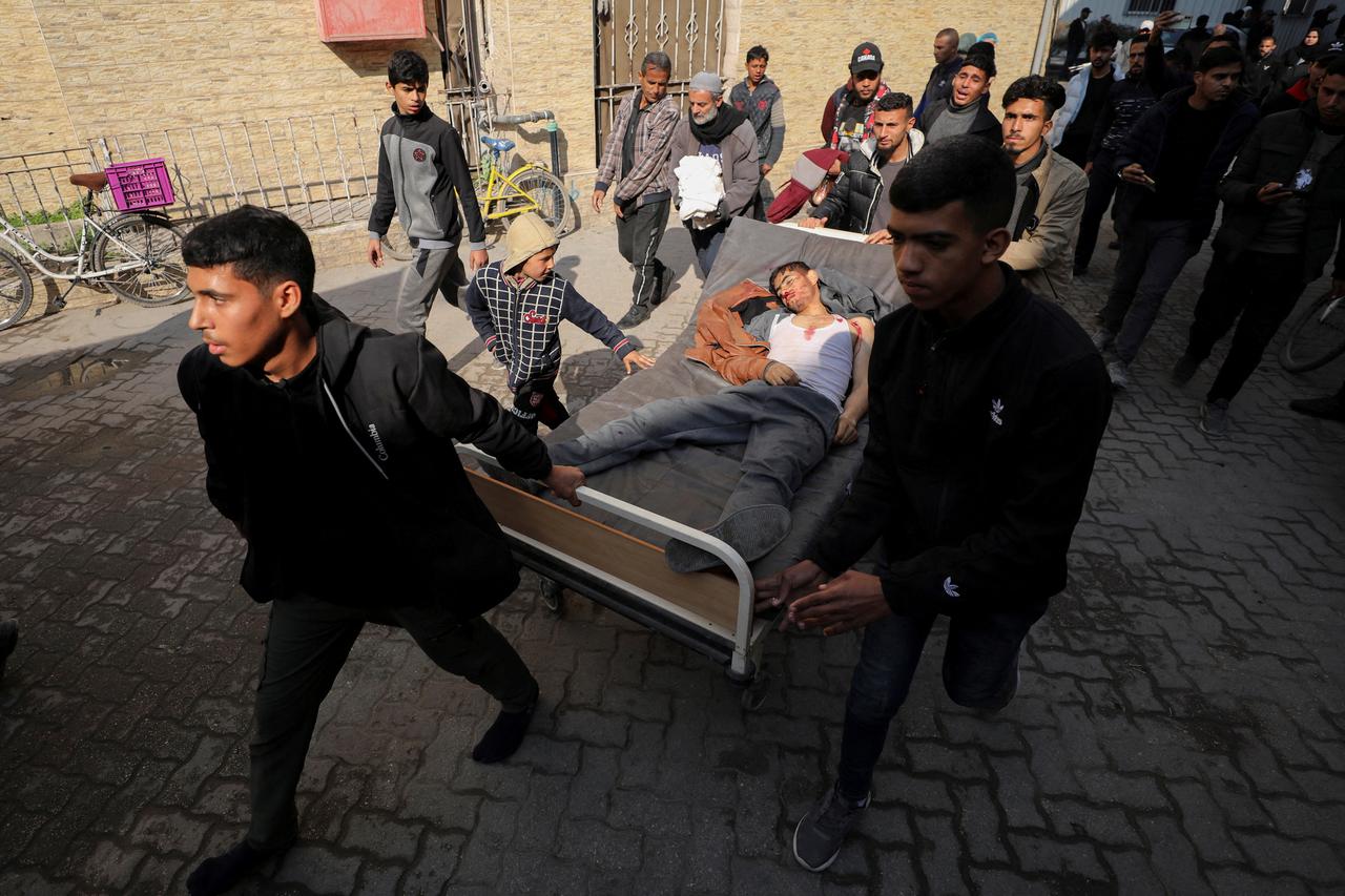 Mourners transport the body of a Palestinian killed in an Israeli strike, amid the ongoing conflict between Israel and Hamas, at Al-Ahli Arab Baptist Hospital in Gaza City