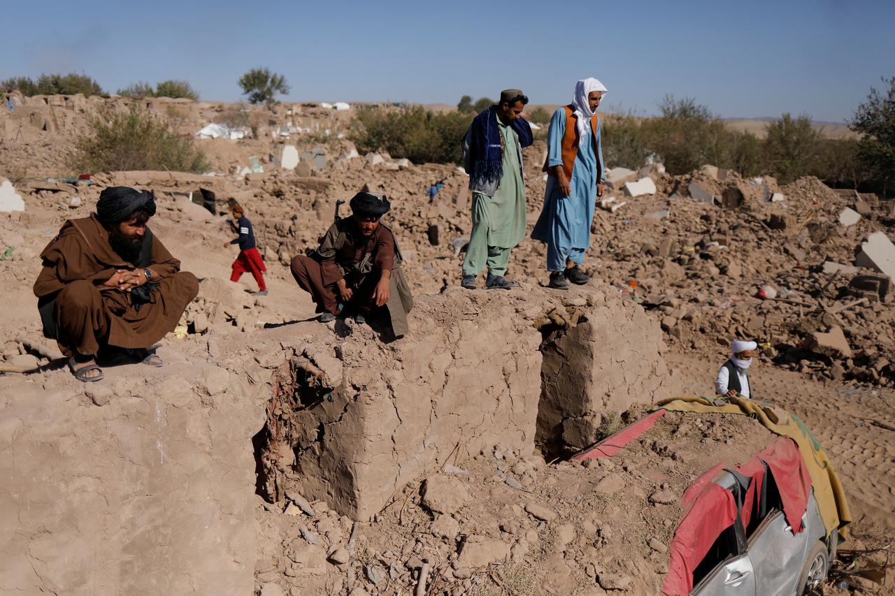 Taliban soldiers stand on a wall in the aftermath of an earthquake in the district of Zinda Jan, in Herat