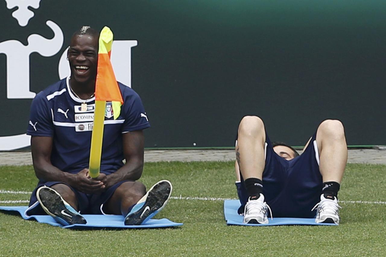 'Italy\'s soccer player Mario Balotelli (L) plays with a corner flag during a training session during the Euro 2012 in Krakow June 20, 2012.   REUTERS/Tony Gentile (POLAND  - Tags: SPORT SOCCER)  '