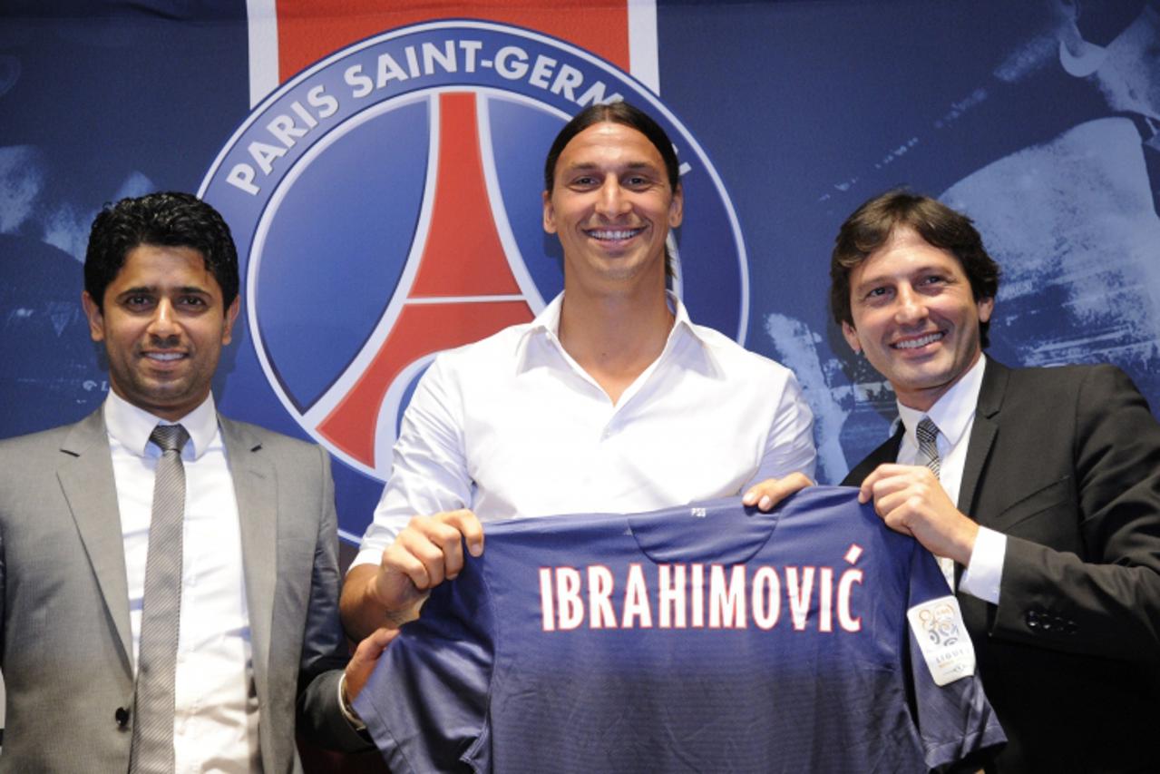 'TOPSHOTS Paris Saint-Germain (PSG) football club\'s newly recruited Sweden striker Zlatan Ibrahimovic (C), poses with his new jersey next to Paris Saint-Germain (PSG) football club\'s chairman Nasser