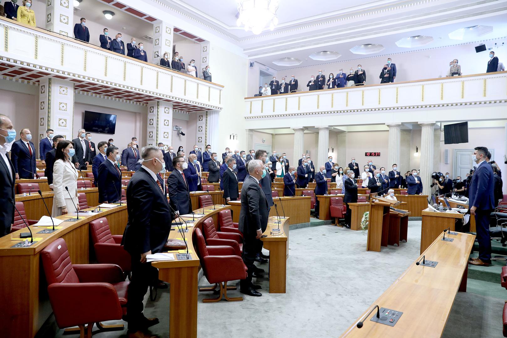 Upravo stoga odlučili smo fotografijama podsjetiti na konstituirajuću sjednicu 10. saziva Hrvatskog sabora, kada je harao koronavirus i izabrani zastupnici u prostorijama Sabora nosili su maske. 