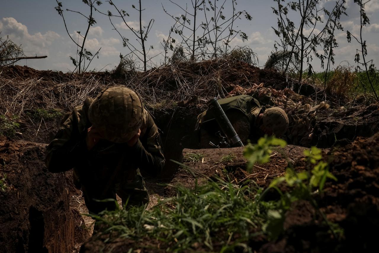 Ukrainian service members fire a mortar at a front line near the city of Bakhmut