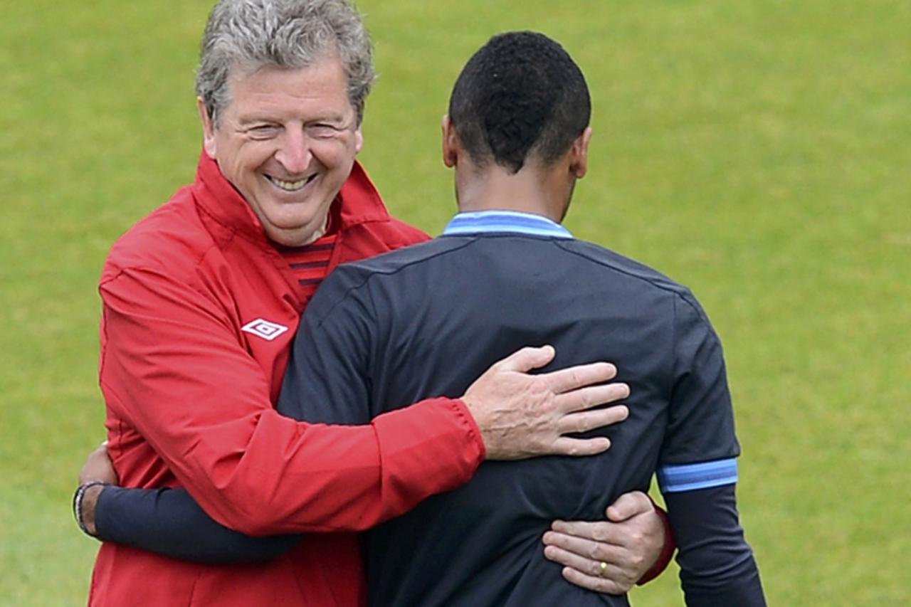 'England soccer coach Roy Hodgson (L) reacts with Ashley Cole during a training session at the Hutnik stadium in Krakow June 22, 2012, ahead of their Euro 2012 soccer match against Italy.   REUTERS/Ni