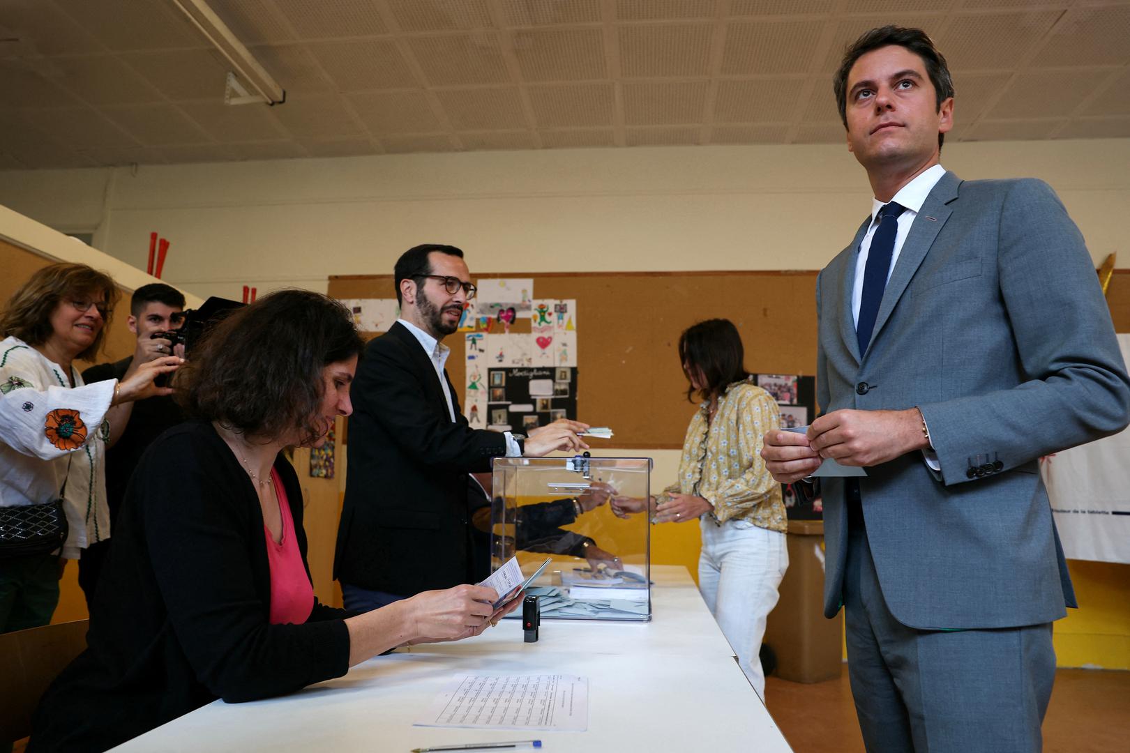 France's Prime Minister Gabriel Attal (R) holds his ballot ahead of voting in the second round of France's parliamentary elections at a polling station in Vanves, suburb of Paris, France on July 7, 2024.     ALAIN JOCARD/Pool via REUTERS Photo: ALAIN JOCARD/REUTERS